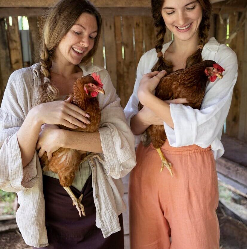 front-view-smiley-women-holding-chickens_23-2149456973 (1)
